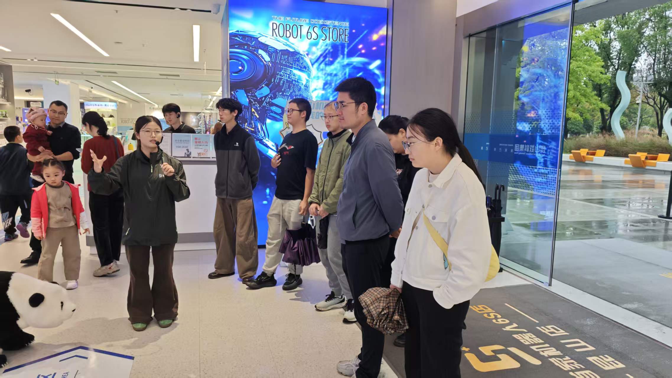 课题组成员听取机器人6S店展厅讲解